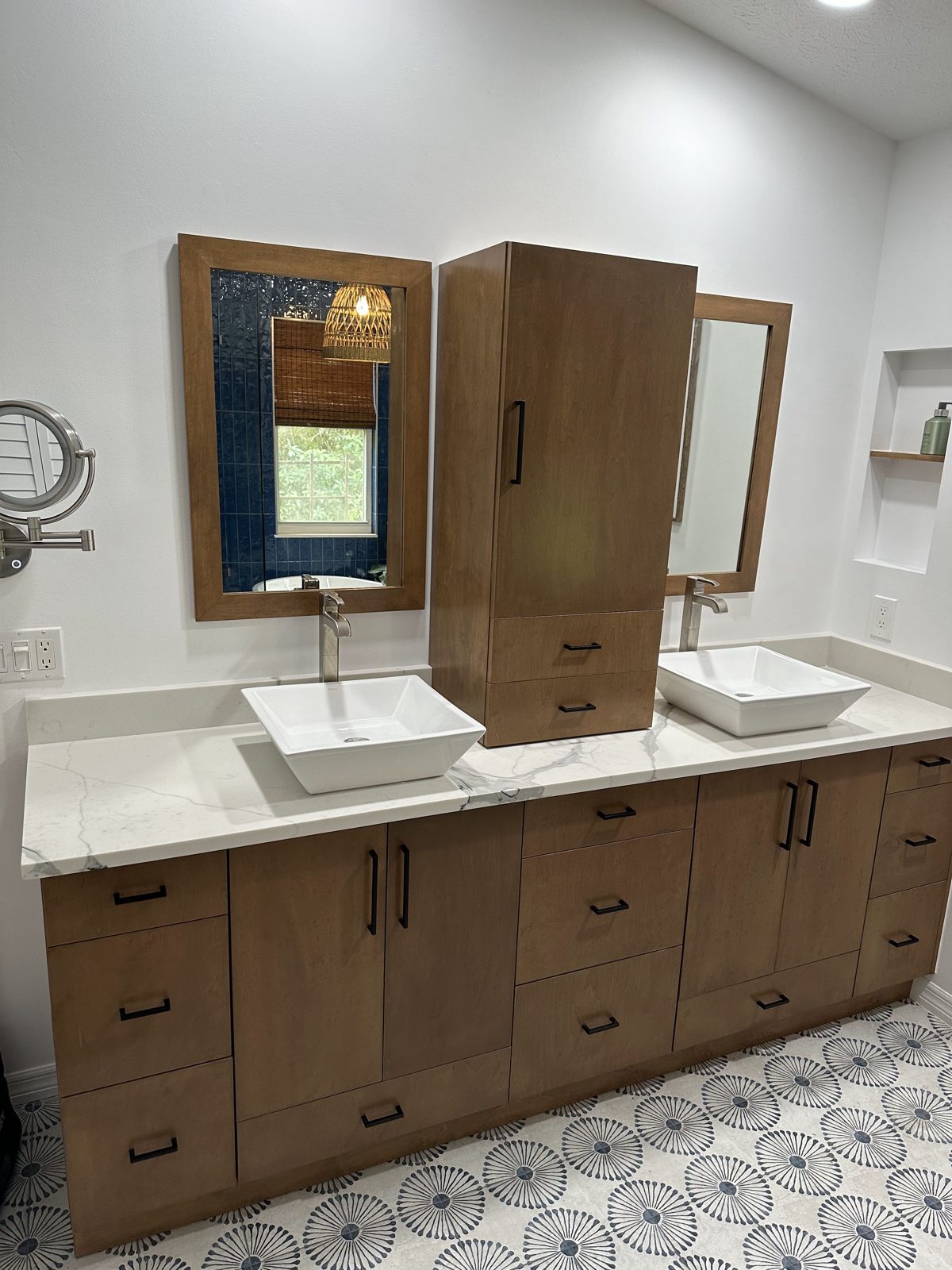 Double vanity with walnut cabinetry and patterned tile floor