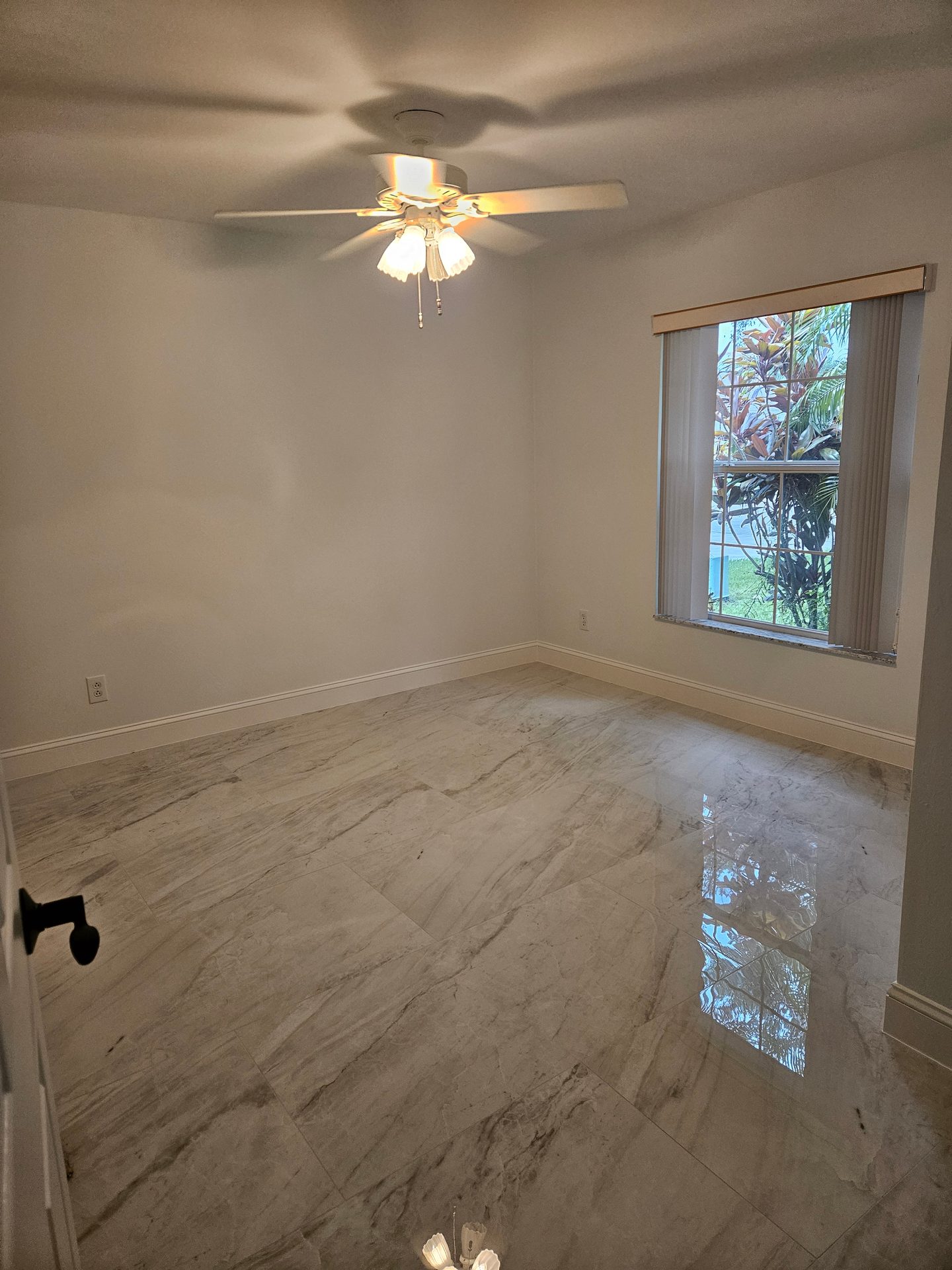 Bedroom with new marble-look porcelain tile flooring and fresh baseboards